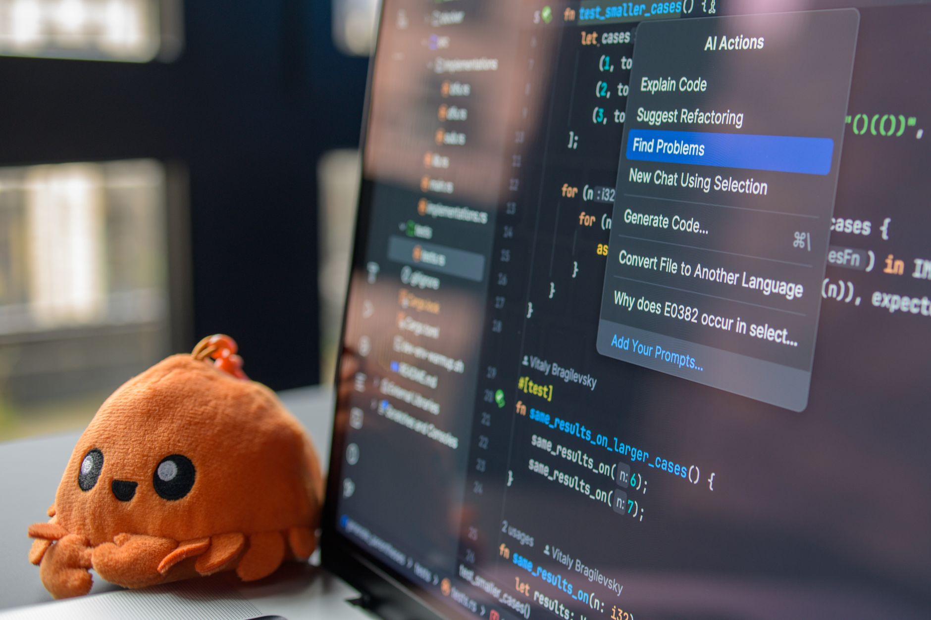 Developer typing code on a laptop with AI autocomplete suggestions visible