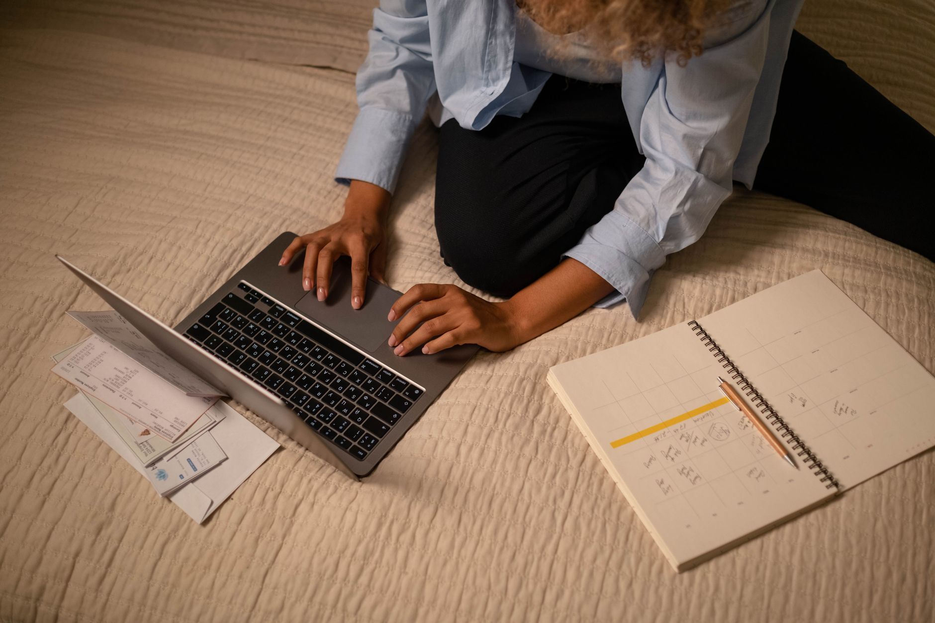 Woman at desk printing colorful planner pages from a laptop