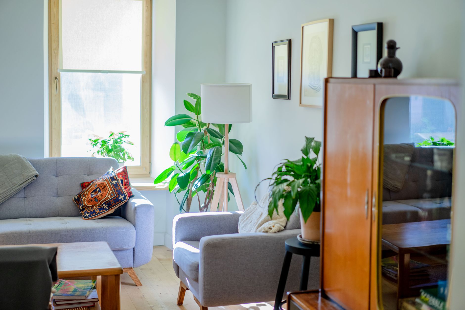 a framed abstract wall art print hanging above a sofa in a bright living room