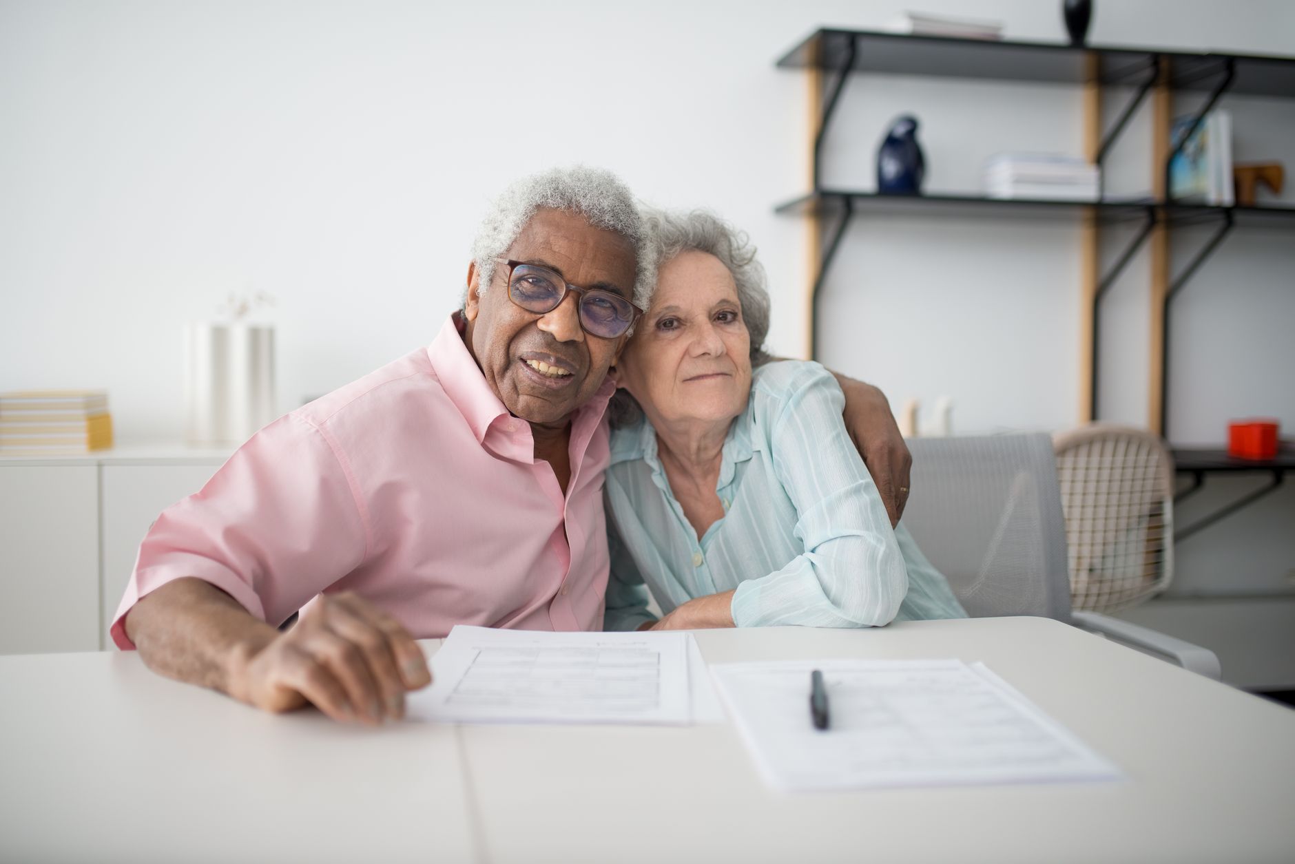 Senior adult reviewing Social Security paperwork and bank statements at home table