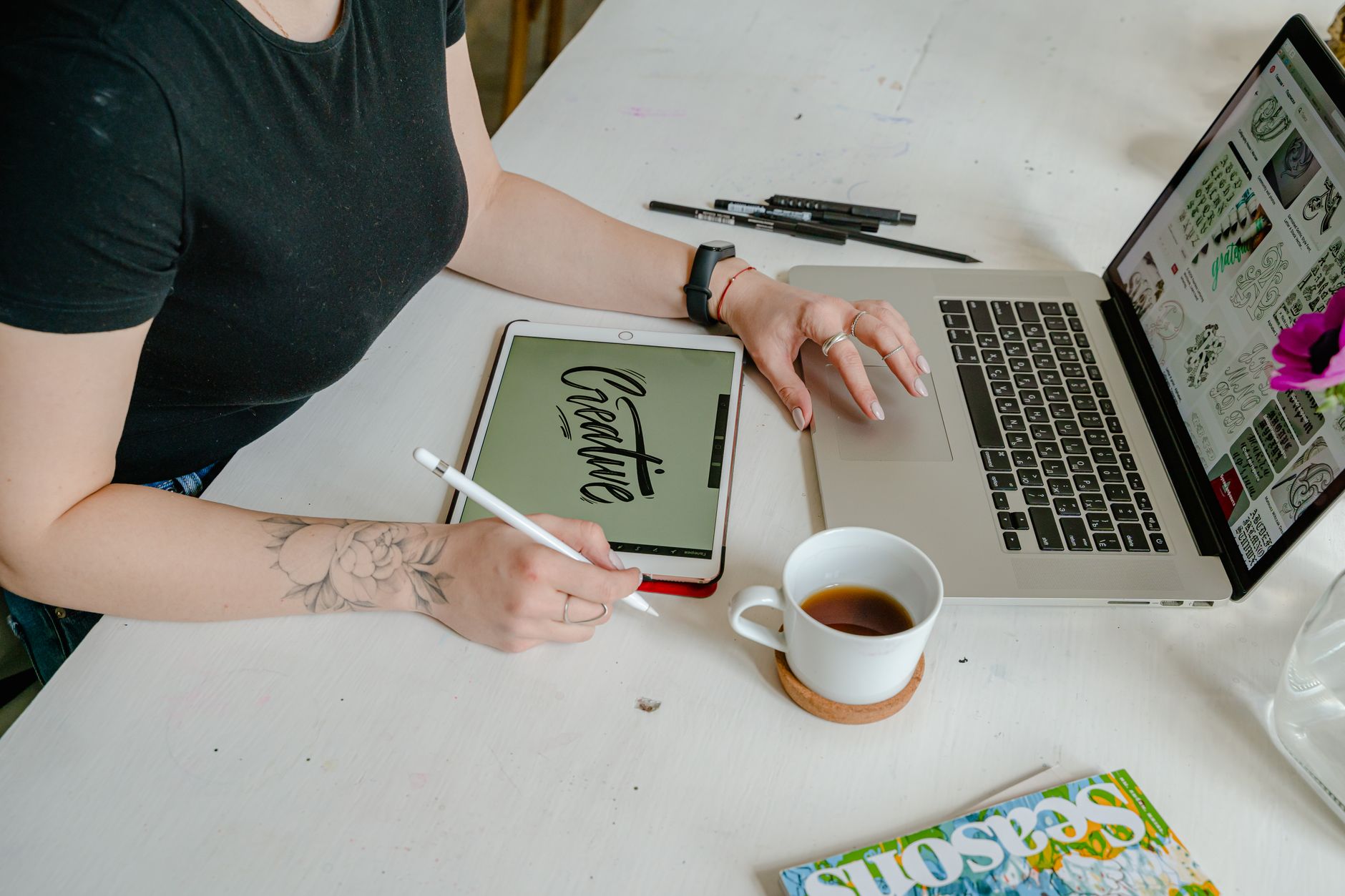 a digital planner open on a tablet next to a laptop and a cup of coffee