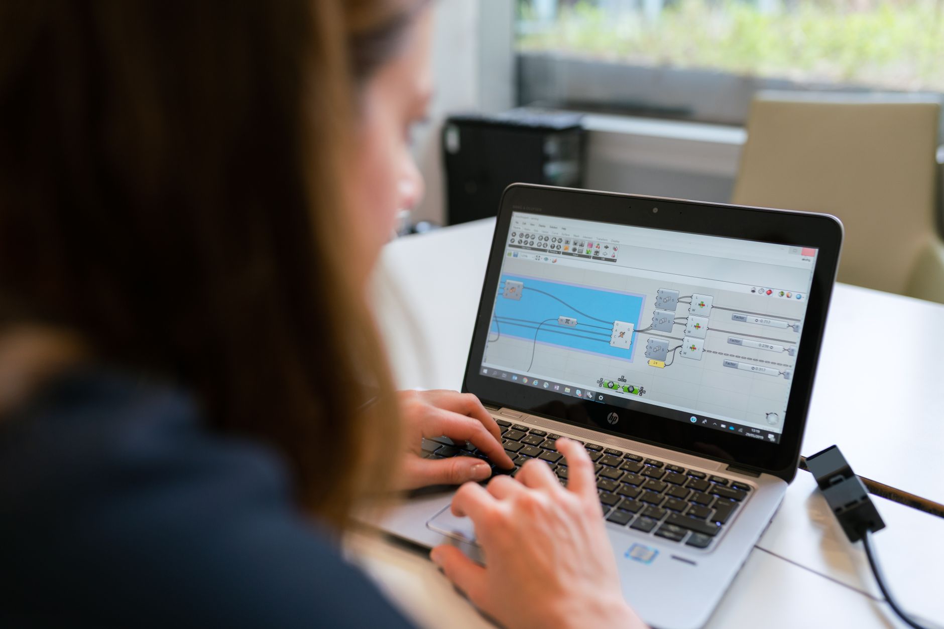 a person setting up an automation workflow on a laptop with a node graph interface