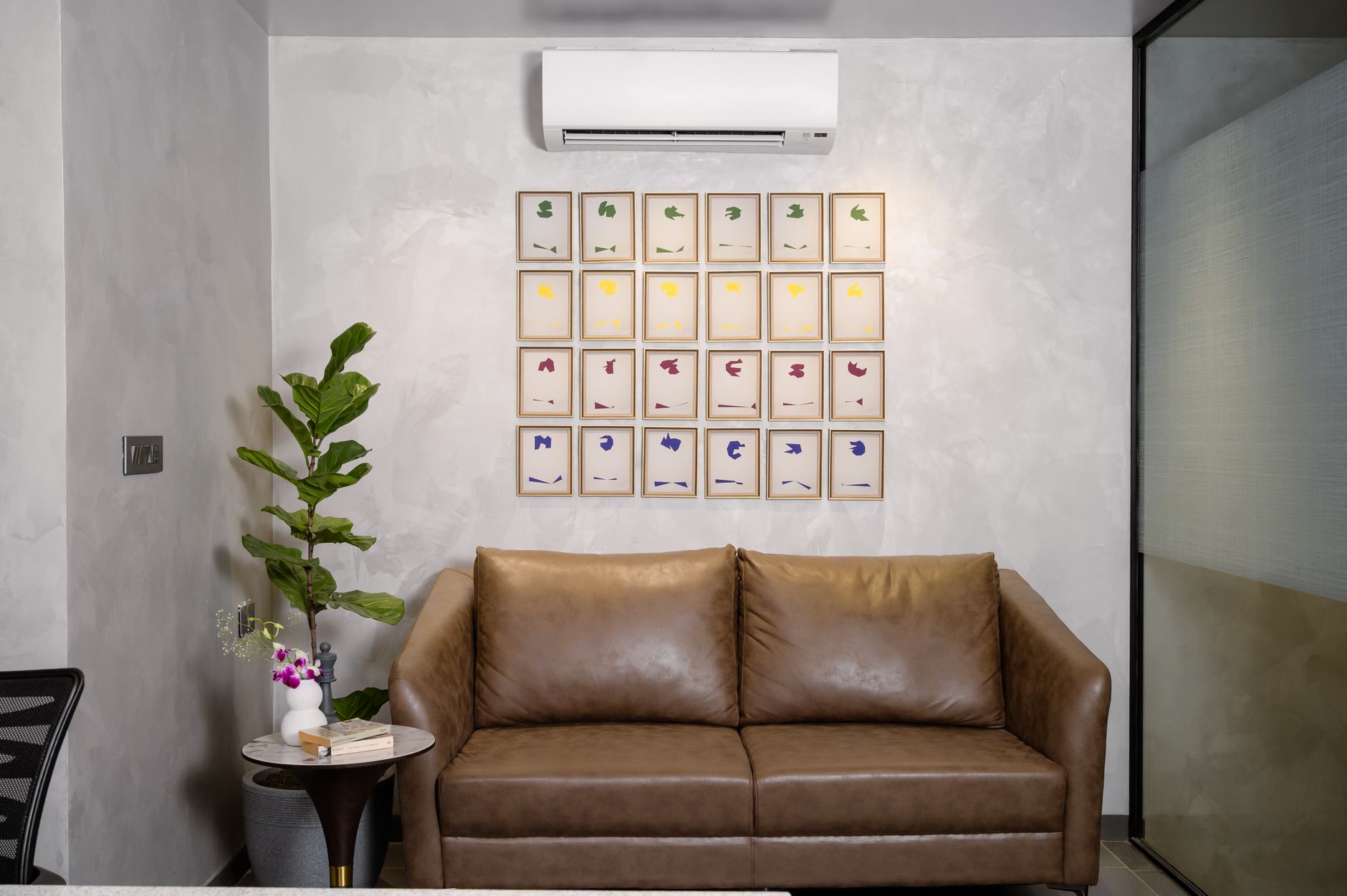 a framed botanical print hanging on a living room wall above a neutral sofa
