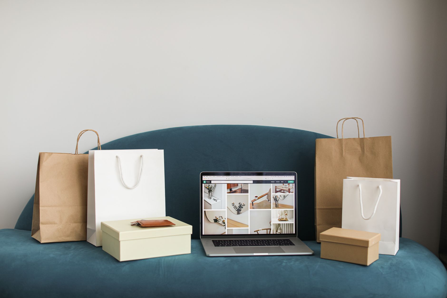 A laptop screen showing a digital product shop while a person prepares product images