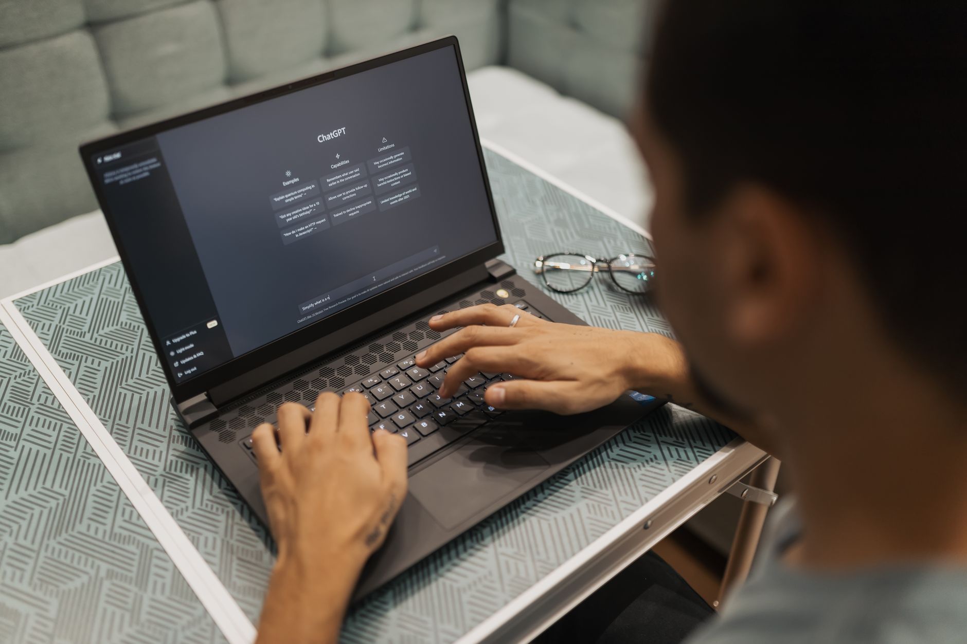 Person typing on laptop with an AI chat interface visible on the screen
