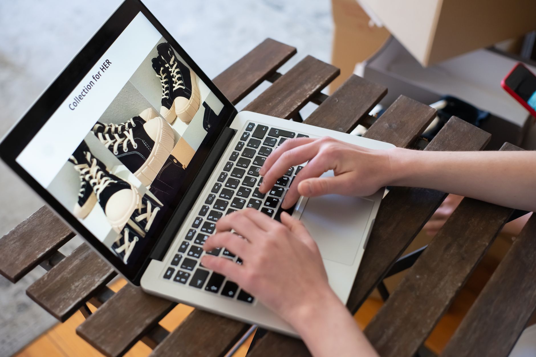 A person looking at a laptop showing an online digital product store with product listings and prices