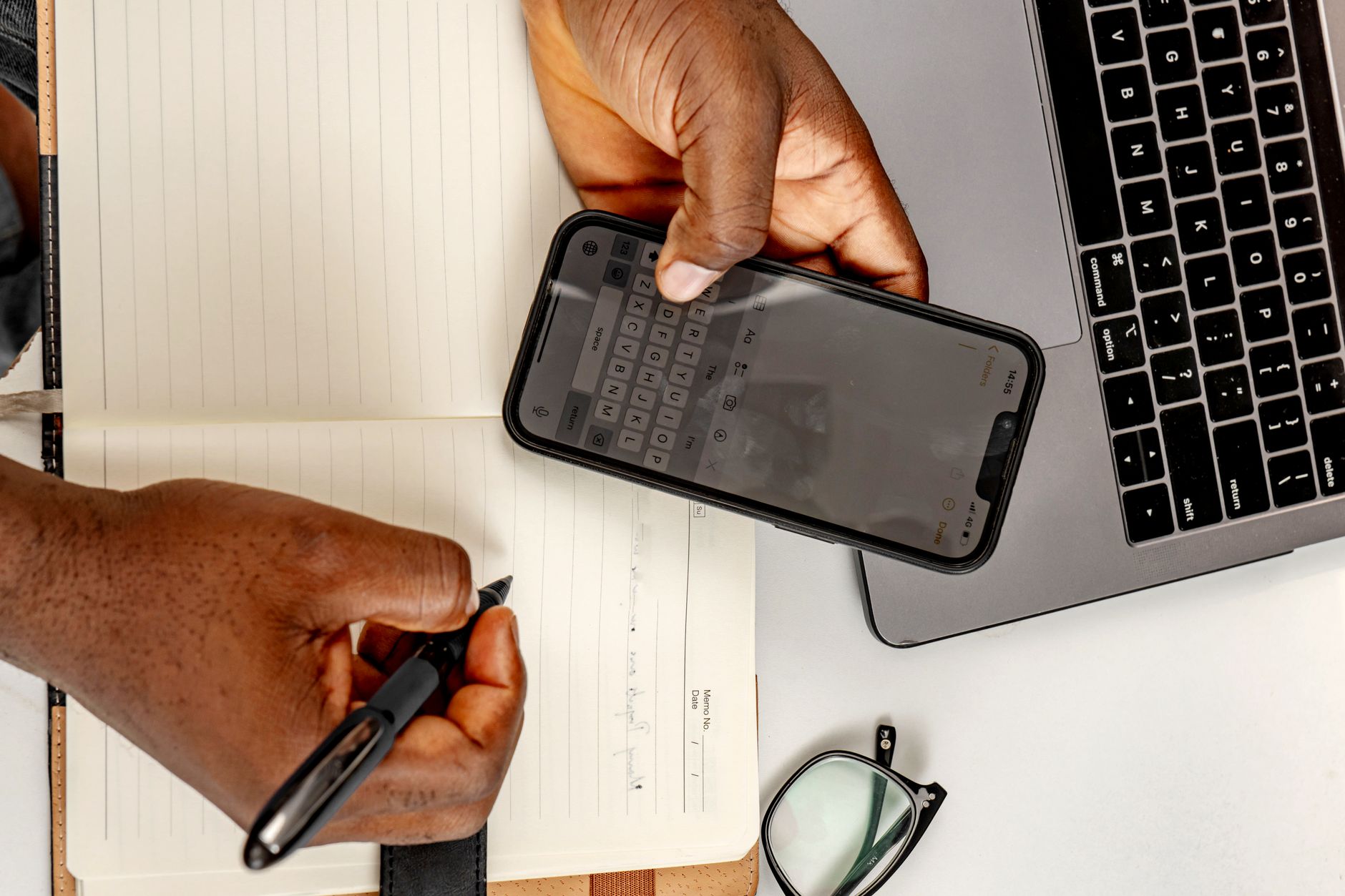 a woman checking the Notion app on a smartphone at a desk