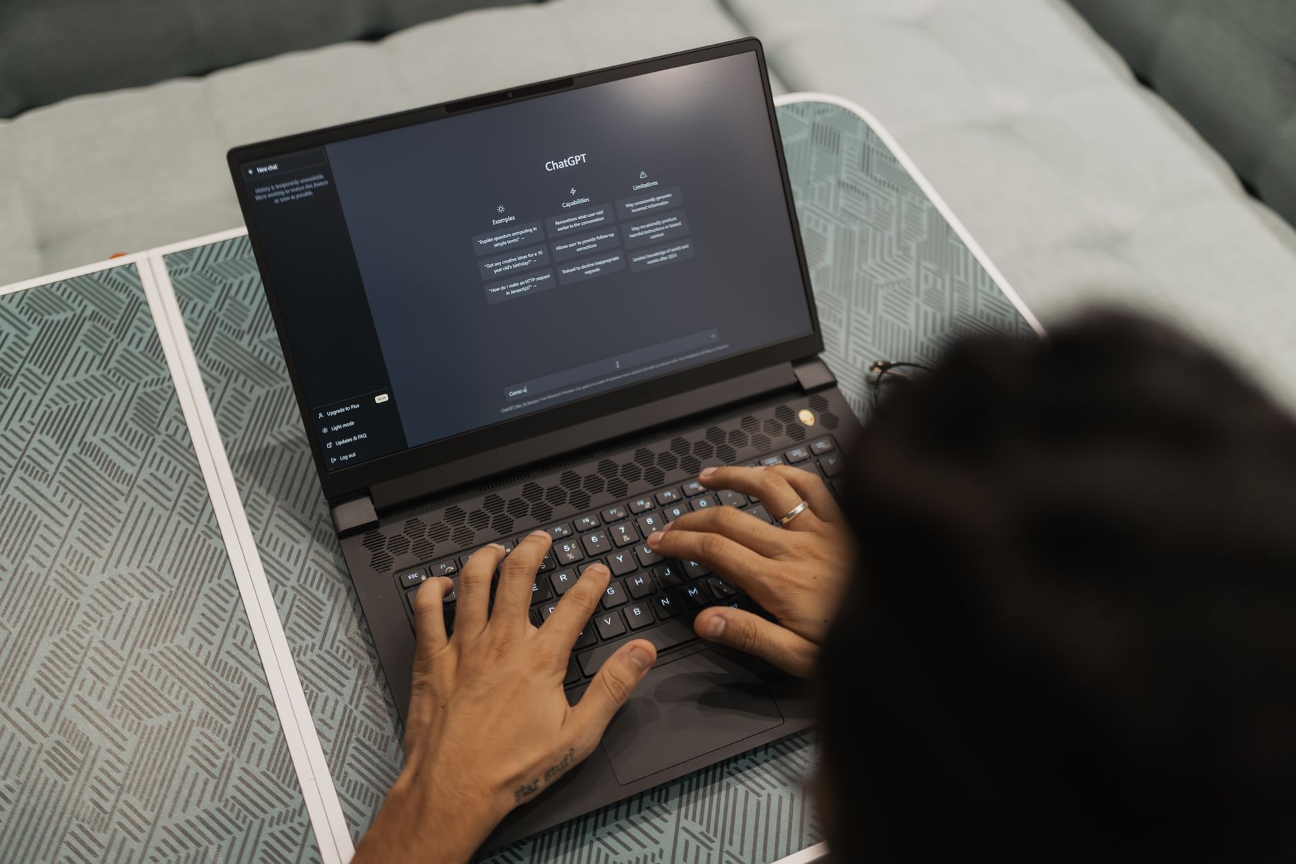 person typing a prompt into ChatGPT on a laptop screen